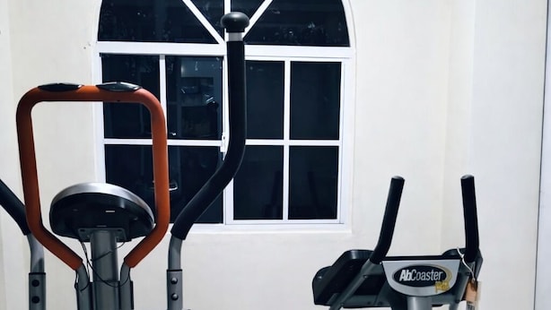 Un gimnasio en casa con una elíptica, una bicicleta estática y una cinta de correr.
