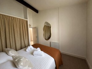 Quarto de hotel com cama, espelho e radiador.