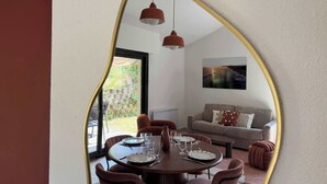 Un coin repas avec une table ronde dressée pour six personnes, entourée de six chaises.