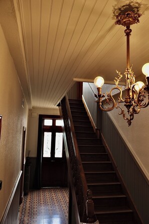 A staircase with a wooden handrail and a patterned floor. - A Trip to the Canal (Moissac)