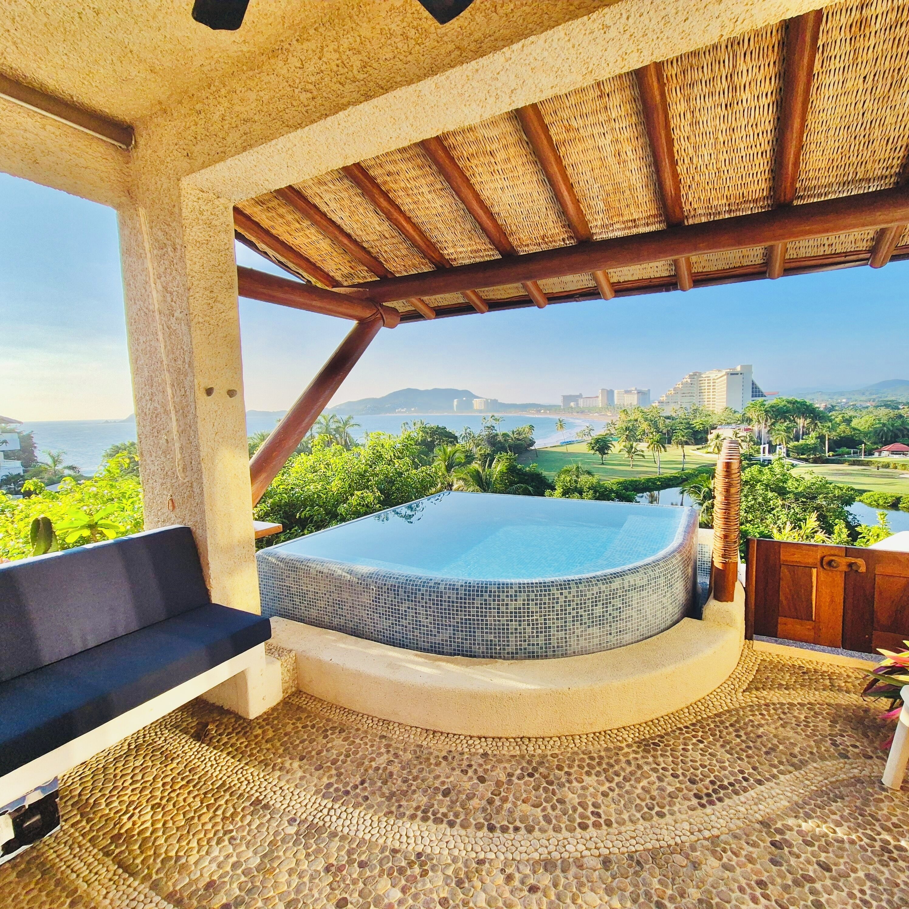 A hot tub with a view of the ocean and cityscape.