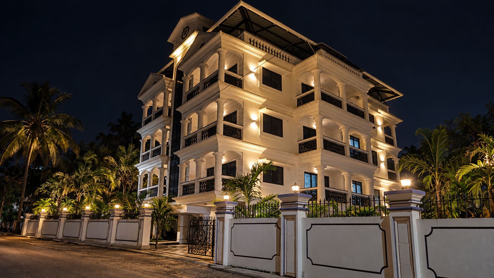 Um hotel com vários andares, varandas, portão fechado e palmeiras.