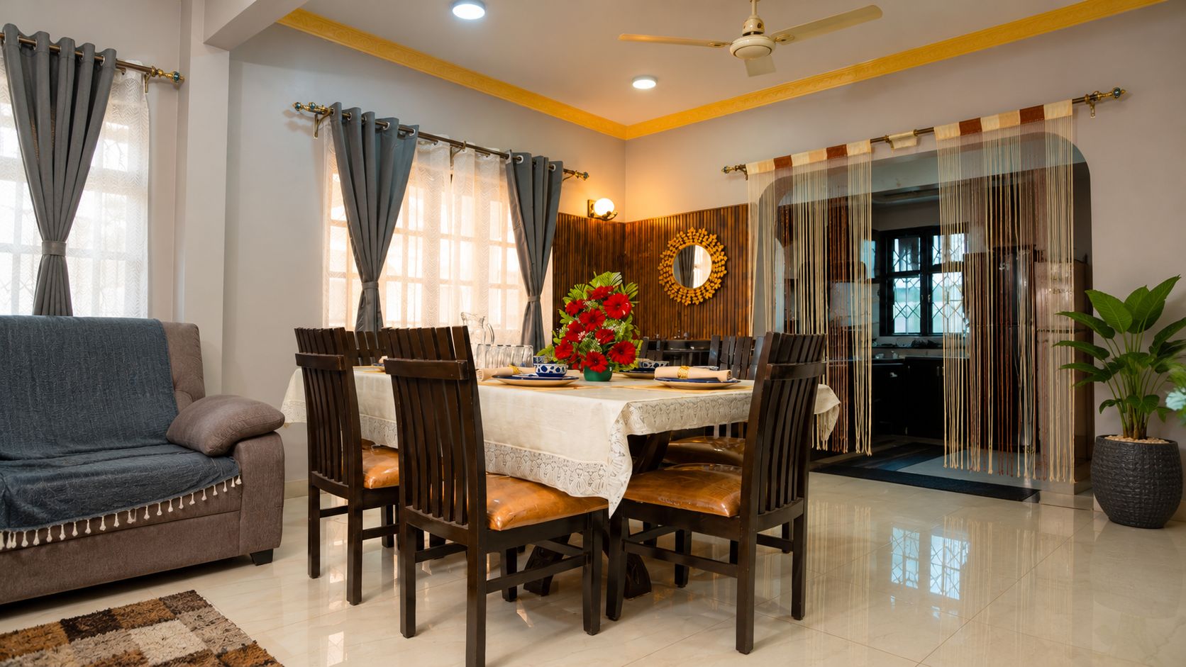A dining area with a round table, chairs, and a sofa.