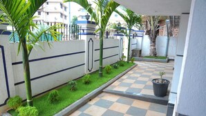 A checkered outdoor area with a low wall, small shrubs, and a potted plant. - Casa de Souza (Verna)