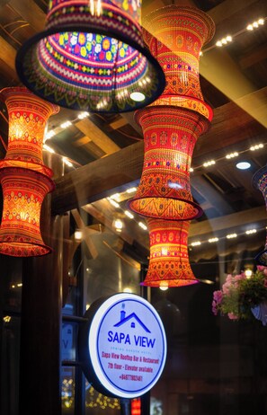 A hotel interior with multiple hanging decorative lights and a sign indicating the Sapa View restaurant on the 7th floor. - Mountain View Homestay SaPa (Sa Pa)