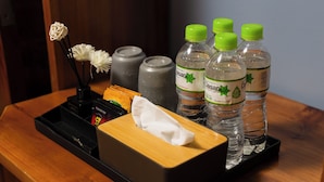 A wooden tray with a tissue box, a black pen holder, and several Dasani water bottles. - Mountain View Homestay SaPa (Sa Pa)
