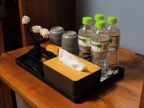 A wooden tray with a tissue box, a black pen holder, and several Dasani water bottles. - Mountain View Homestay SaPa (Sa Pa)