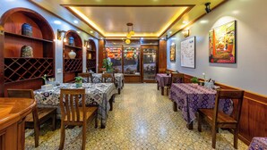 A restaurant with wooden furniture, patterned tablecloths, and a tiled floor. - Mountain View Homestay SaPa (Sa Pa)