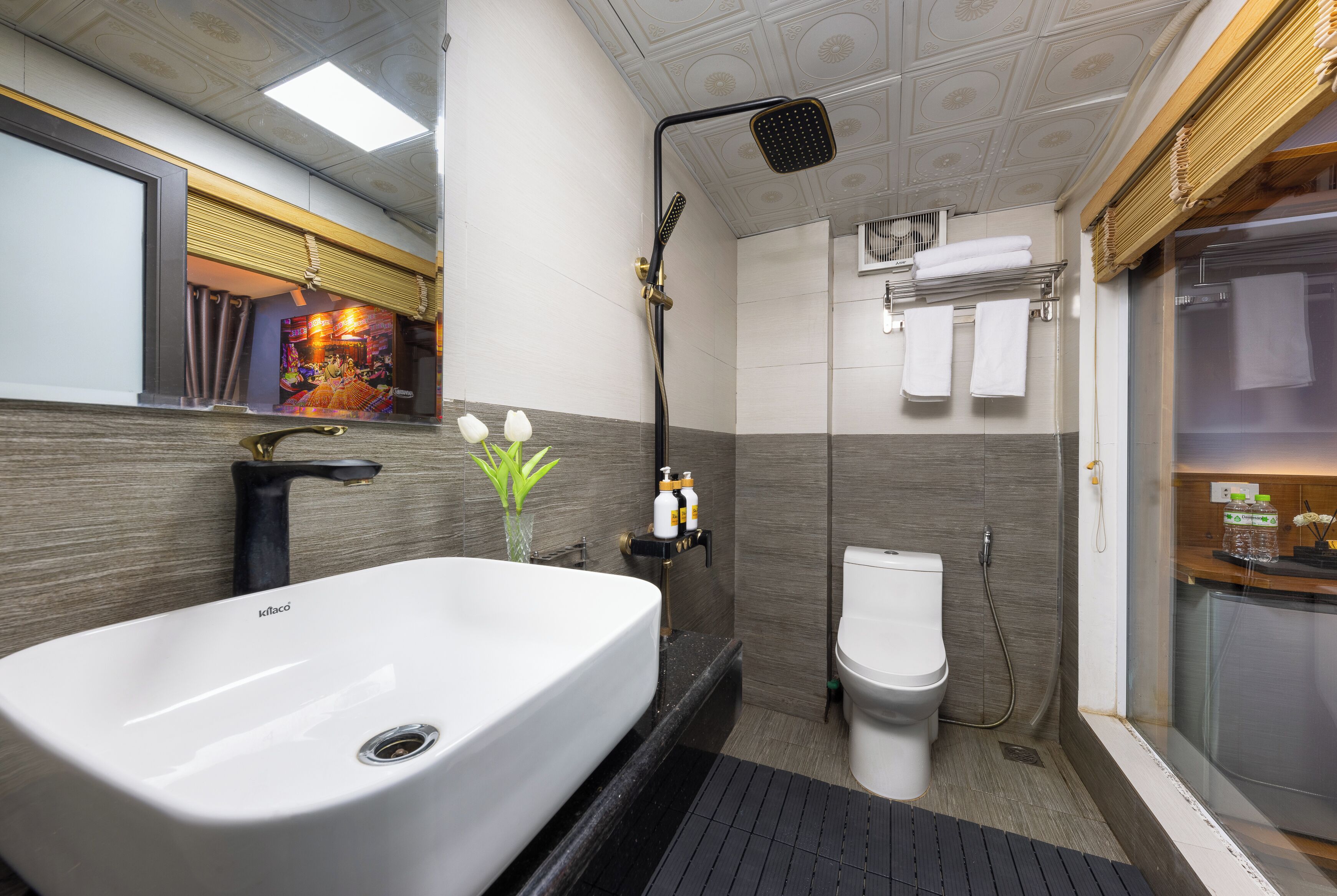 Un baño moderno con un lavabo blanco grande, una ducha y un inodoro.