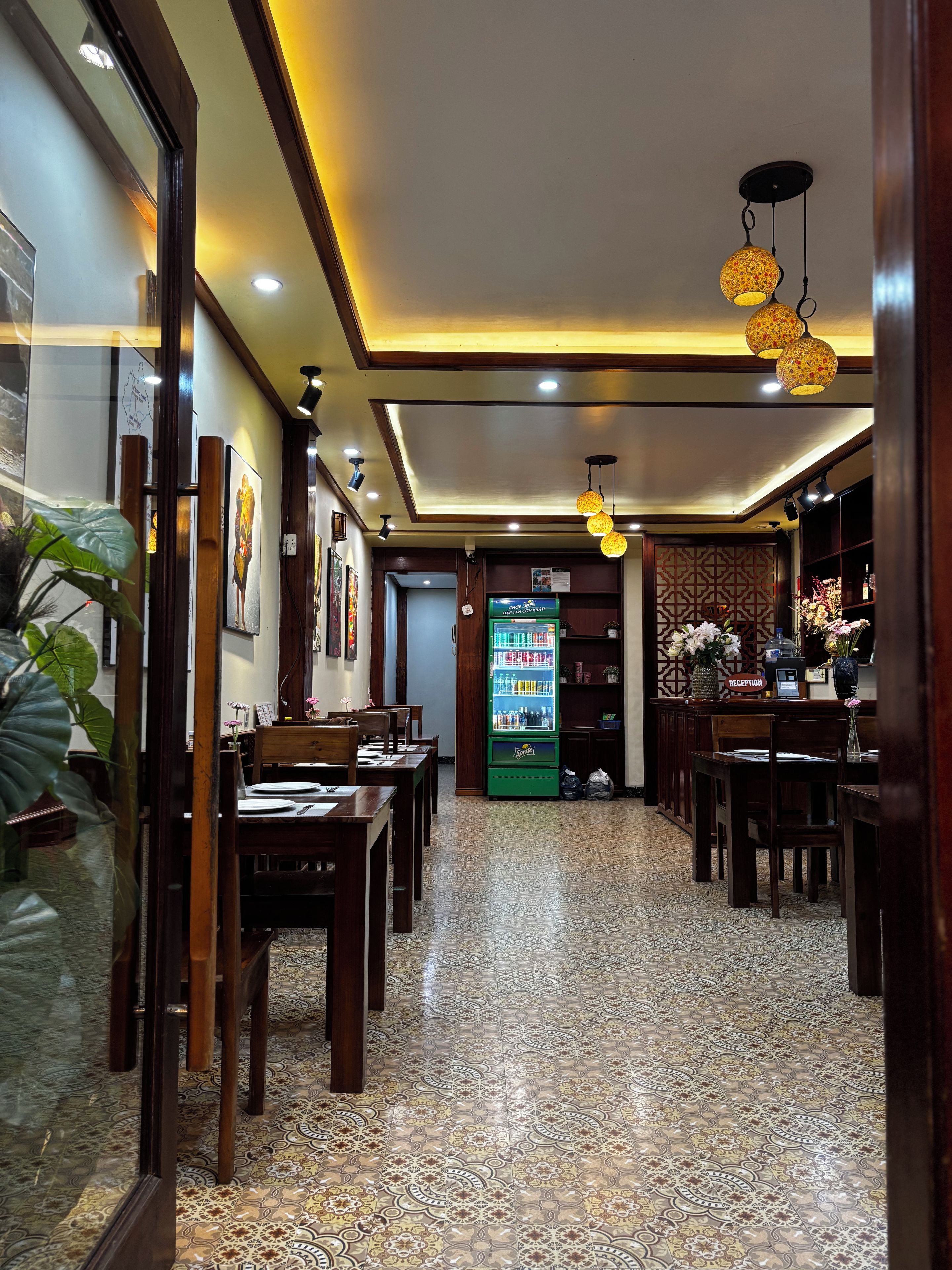 Eine Hotelhalle mit Rezeption, Sitzgelegenheiten, einem gemusterten Boden und dekorativer Beleuchtung.