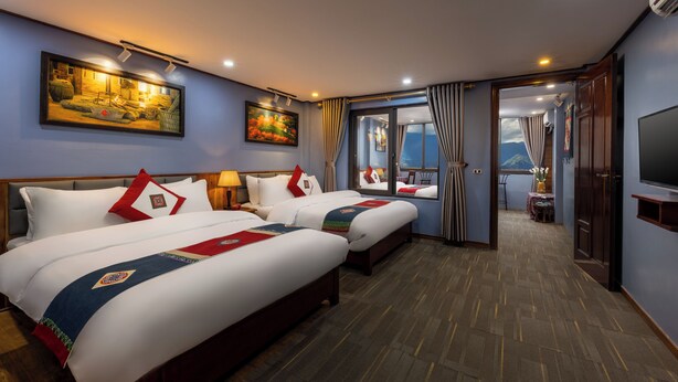 A hotel room with two beds, a TV, a painting, and a view of the mountains. - Mountain View Homestay SaPa (Sa Pa)