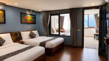 Una habitación de hotel con dos camas, un cuadro en la pared y vistas a través de la puerta.