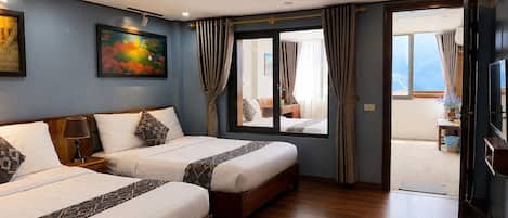 Ett hotellrum med två sängar, en tavla på väggen och utsikt genom dörren.