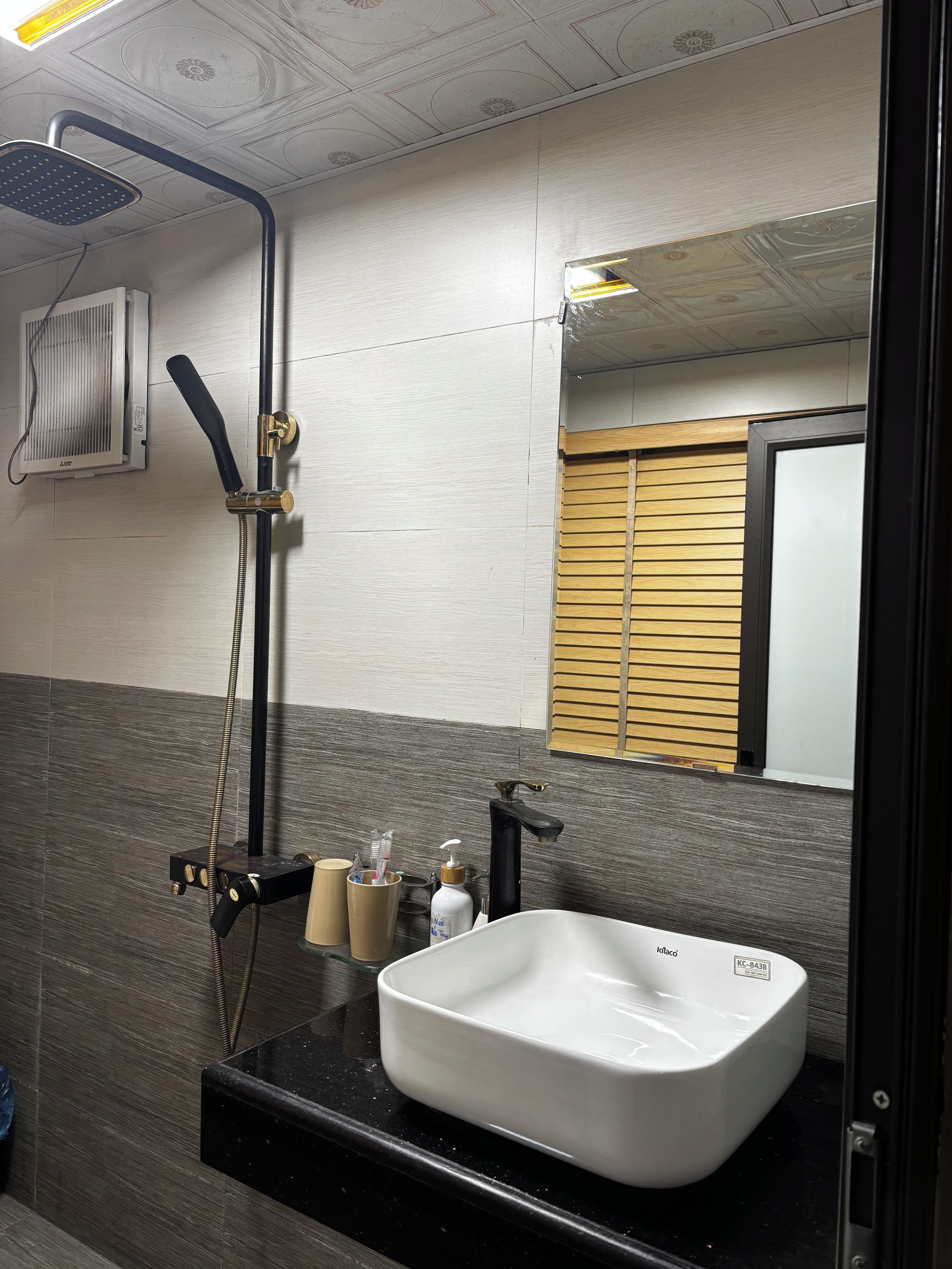 A bathroom with a shower, a sink, and a mirror.