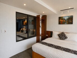 A hotel room with a large bed, a mirror, a painting, and a wooden wardrobe. - Mountain View Homestay SaPa (Sa Pa)