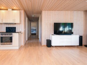 A modern kitchen with built-in appliances and a dining area with a large flat-screen TV. - 8 Person Holiday Home in Hovborg (Hovborg)
