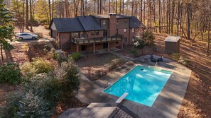 A two-story house with a swimming pool, a covered deck, and a car parked in the driveway. - Mins to Truist Park & The Battery | Spacious East Cobb Home for Groups (Marietta)