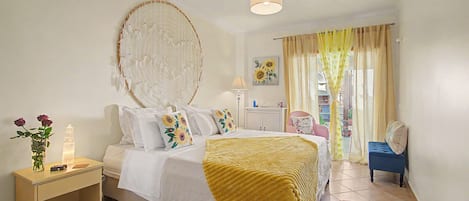 A bedroom with a bed, bedside table, lamp, and a window with curtains.