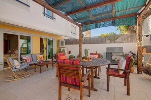 An outdoor patio with a round table, chairs, and a grill. - Apartment 'Magnolia' with Private Terrace, Wi-Fi and Air Conditioning (Tavira)