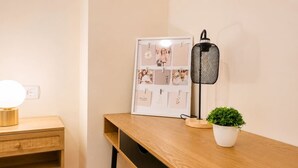 A wooden desk with a framed photo collage, a black mesh lamp, and a small potted plant. - Casa Valle Golf | Valle del Este Golf, Beach & Pool with garden in Vera (Vera)