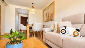 A living room with a sofa, a coffee table, and a dining area with chairs and a table. - Casa Valle Golf | Valle del Este Golf, Beach & Pool with garden in Vera (Vera)