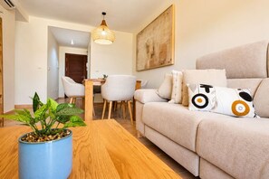 A living room with a sofa, a coffee table, and a dining area with chairs and a table. - Casa Valle Golf | Valle del Este Golf, Beach & Pool with garden in Vera (Vera)