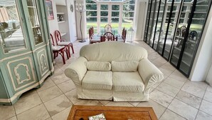 Uma sala de estar com sofá, mesa de centro e área de jantar com cadeiras e mesa.