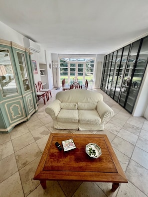 Ein Wohnzimmer mit einer Couch, einem Couchtisch und einem Essbereich mit Stühlen und einem Tisch.
