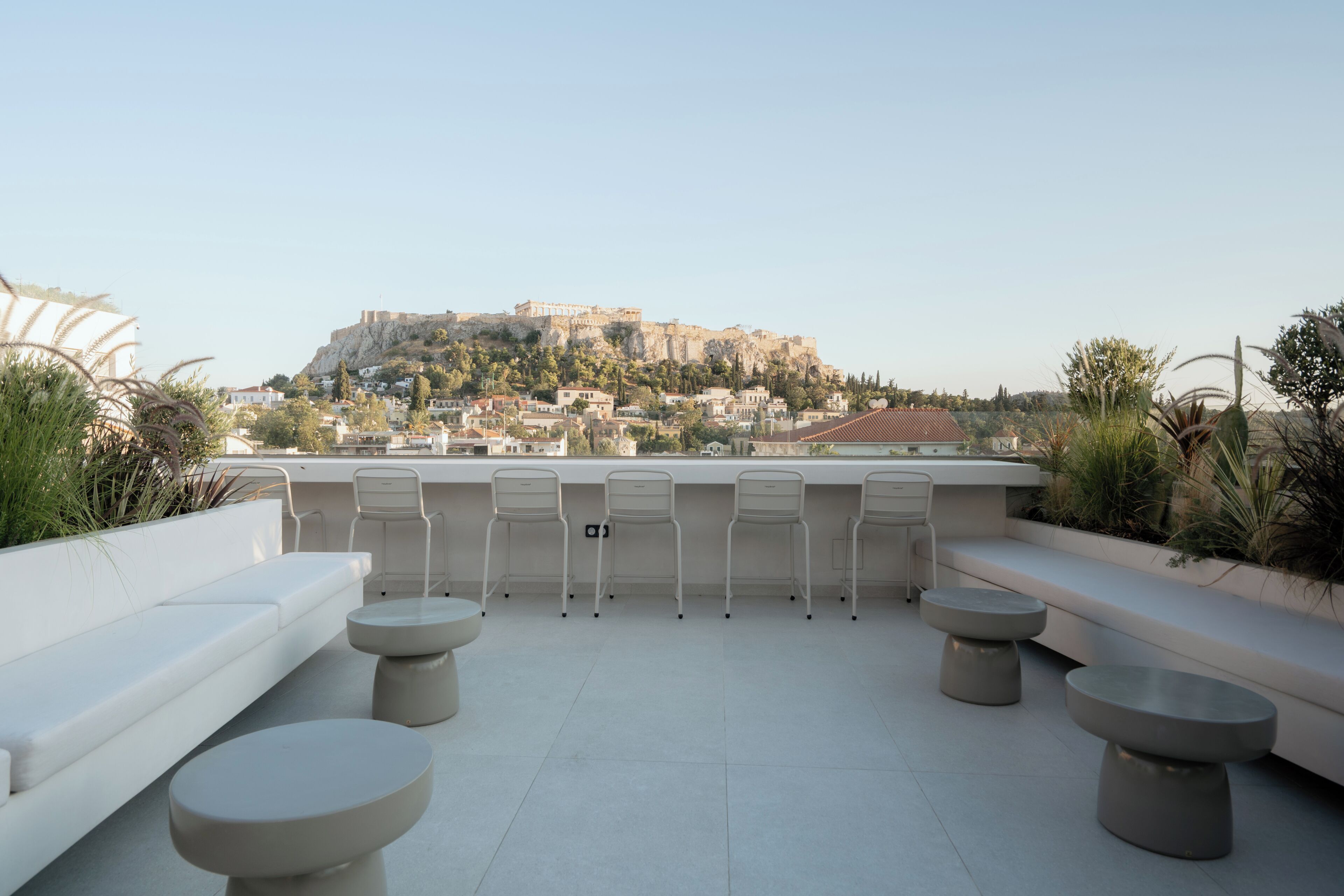 A rooftop terrace with seating and a view of a historic cityscape.