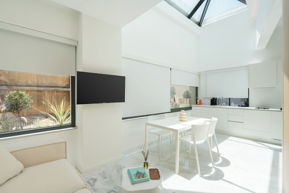 Una cocina moderna con comedor, ventanas amplias y vistas al exterior.