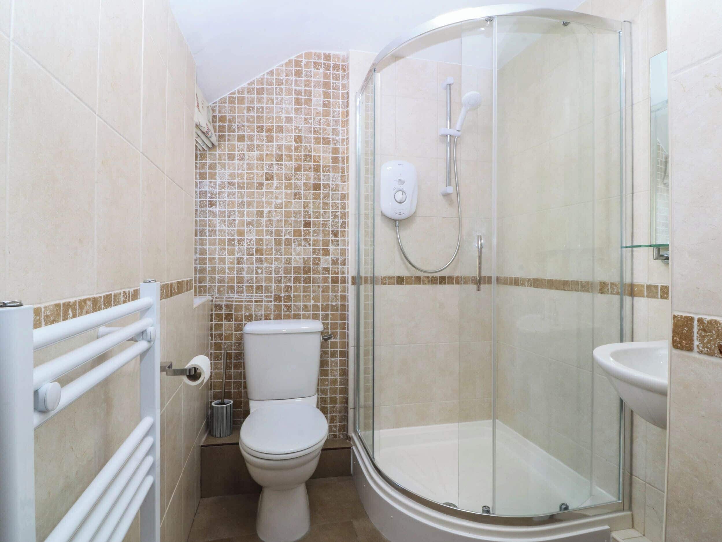 Un baño con inodoro, ducha y lavamanos.