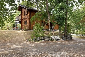 A wooden cabin with a porch, surrounded by trees and a gravel path. - Chambre LUNA Guest Room near Vichy – Shared Pool, Wi-Fi, Air Conditioning (Saint-Rémy-en-Rollat)