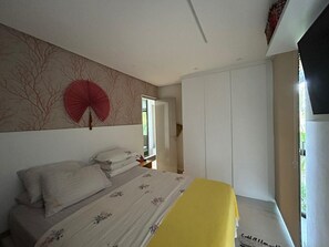 Ein Schlafzimmer mit einem Bett, einem Kleiderschrank und einem Fernseher.