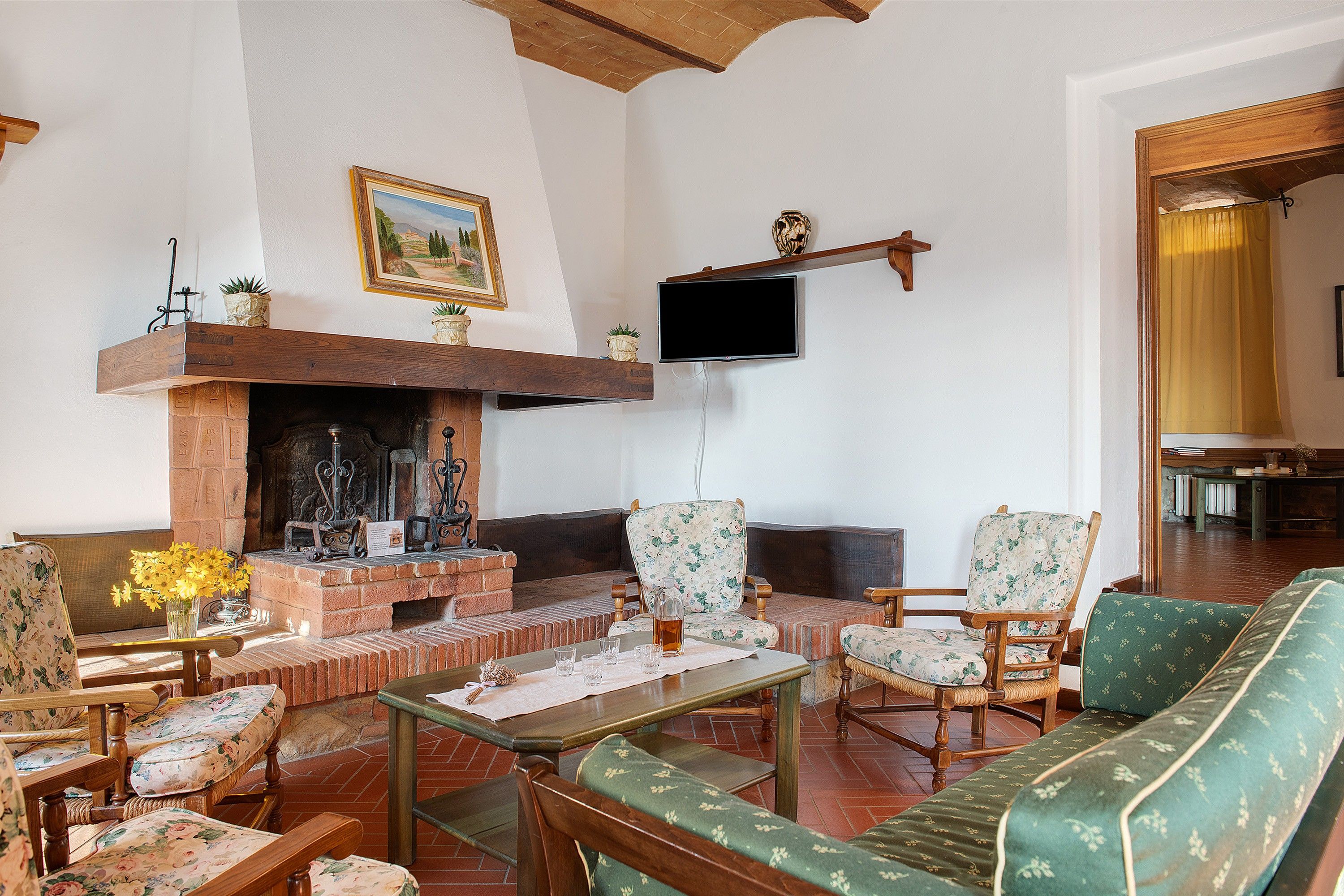 A traditional living room with a fireplace, seating, and a television.