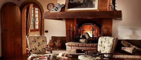 A traditional room with a fireplace, wooden furniture, and a rustic ambiance.