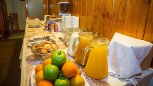 Un bufé de desayuno con frutas, pasteles y bebidas.
