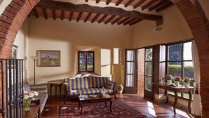 Un accogliente soggiorno con un divano, un tavolo e un quadro appeso al muro.