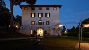 Un edificio grande su due piani, con una facciata simmetrica, numerose finestre e un ingresso centrale.