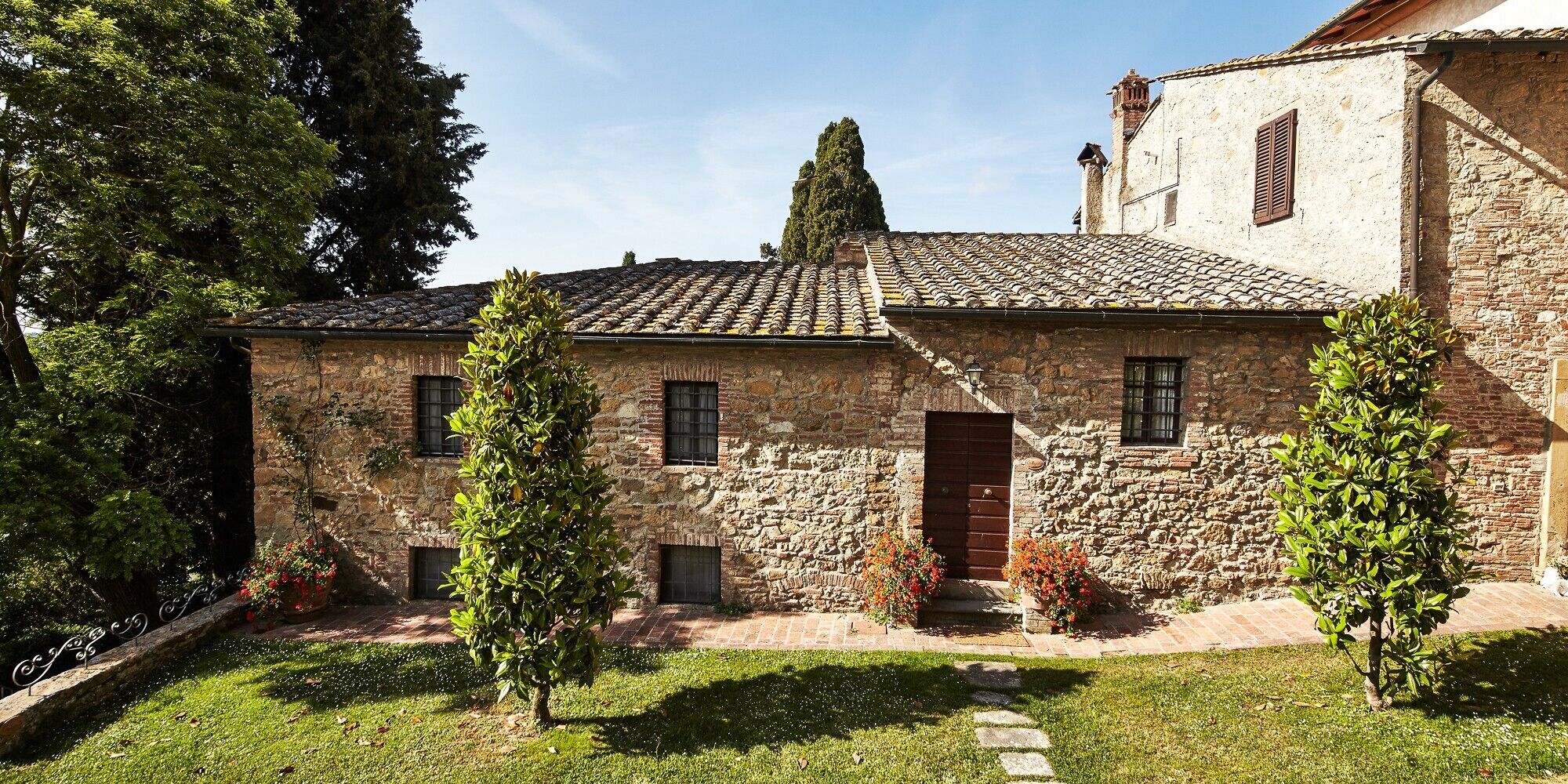A stone building with a tiled roof, a central door, and small windows.