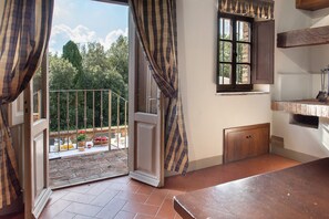 Habitació amb porta corredissa de vidre que dona a un balcó, una finestra i un armari de fusta.