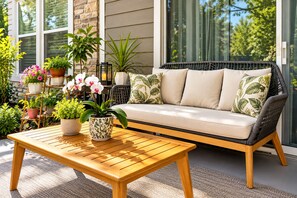 A wicker sofa with cushions, a wooden table, and potted plants on a patio. - Summer Heaven Retreat near Universal Studious, Disney (Lake Buena Vista)