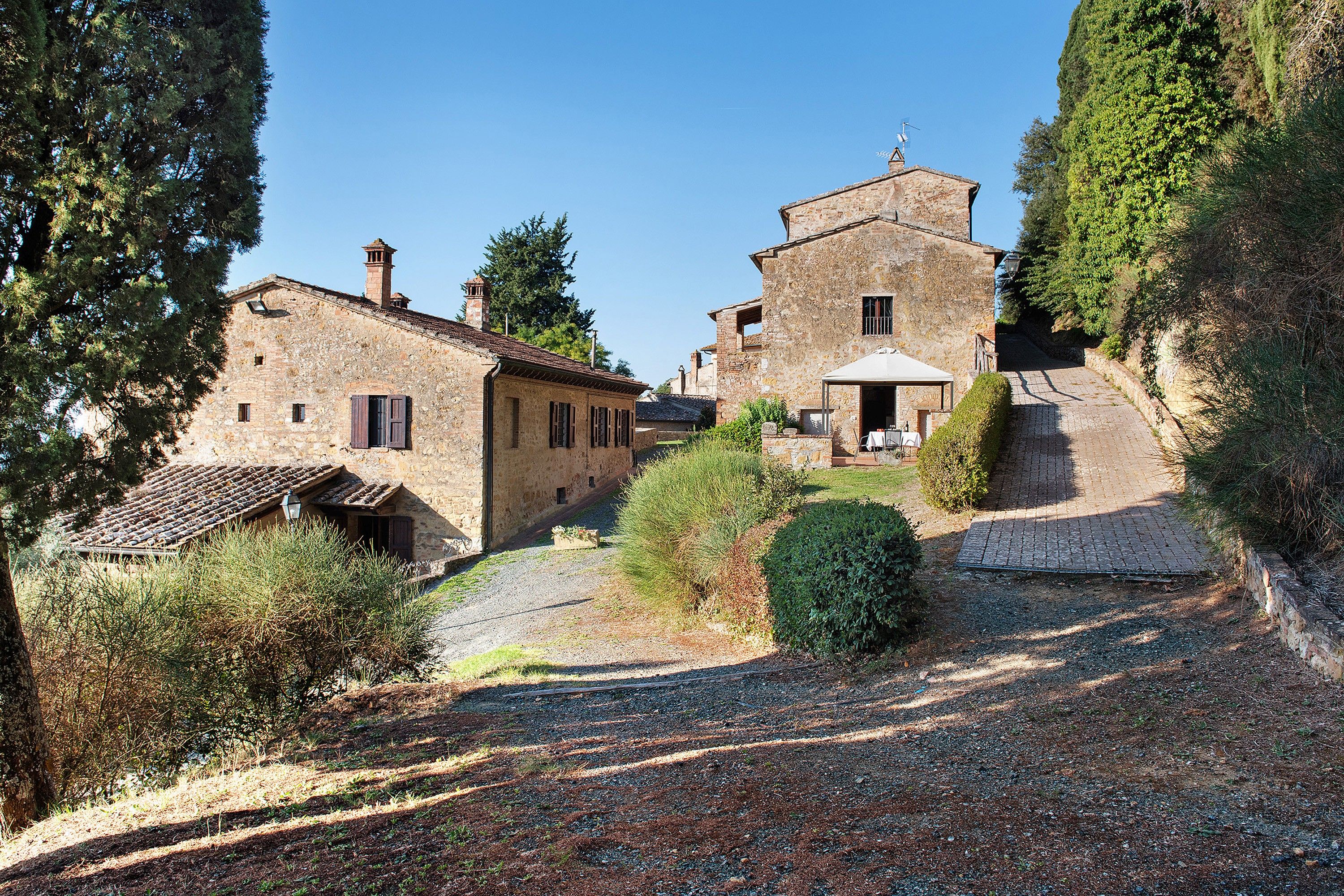 A stone building with a traditional design, featuring a small porch and a covered outdoor seating area.