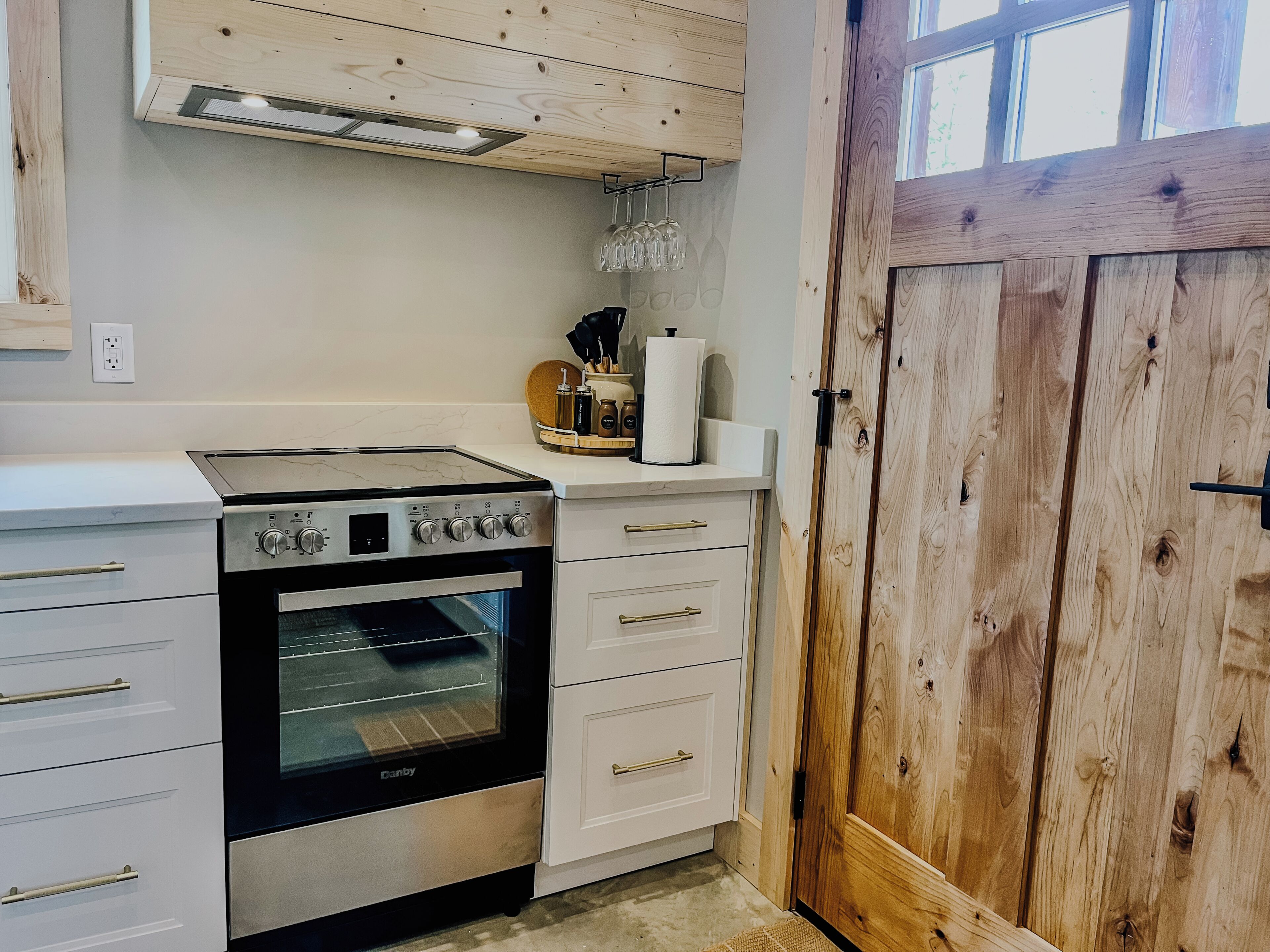 A kitchen with a stove, oven, and white cabinetry.