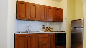 Una cocina con armarios de madera, un refrigerador de acero inoxidable y un lavavajillas.