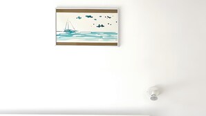 A bedroom with a bed, a nightstand, a wall-mounted light, and a framed picture of a sailboat. - B-Rent La Azotea Zen – Your Relaxing Oasis in Corralejo (Corralejo)