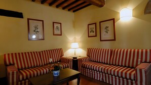 A living room with two striped sofas, a coffee table, and framed botanical prints on the walls. - Querce - Spacious apartment for 8 guests with private outdoor area (Gambassi Terme)