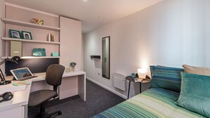 A modern bedroom with a bed, desk, chair, and shelving unit. - Student Only City Village Coventry (Coventry)