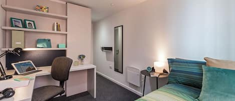 Ein modernes Schlafzimmer mit Bett, Schreibtisch, Stuhl und Regalelement.