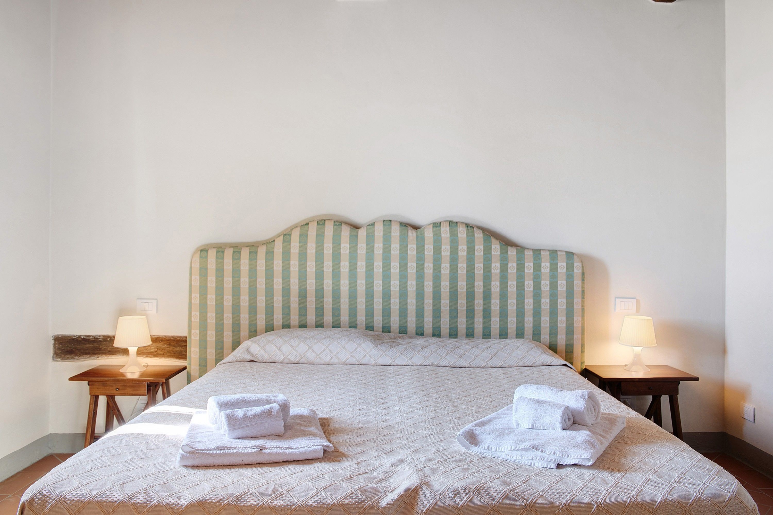 Ein Hotelzimmer mit einem Bett, zwei Nachttischen und zwei Lampen.