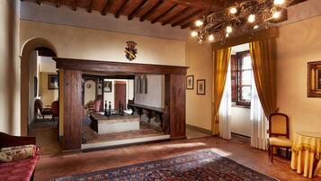 Ein traditionelles Interieur mit einer Holztreppe, einem Chandelier und einem gemusterten Teppich.